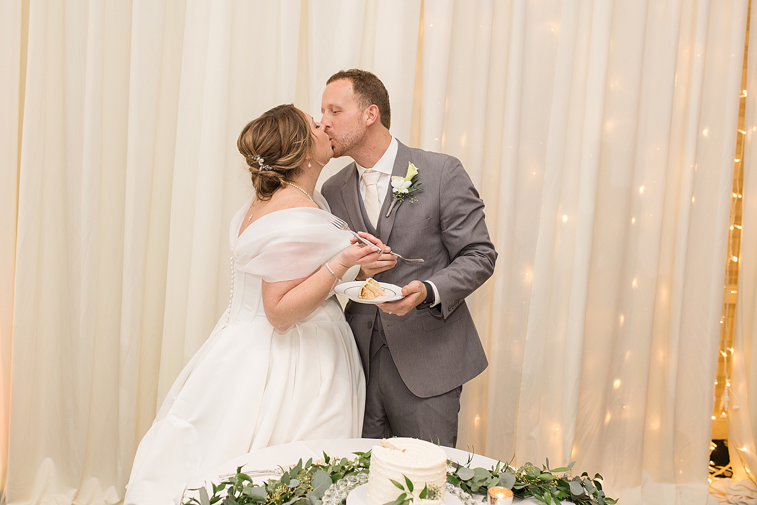 bride and groom kiss after cake cutting