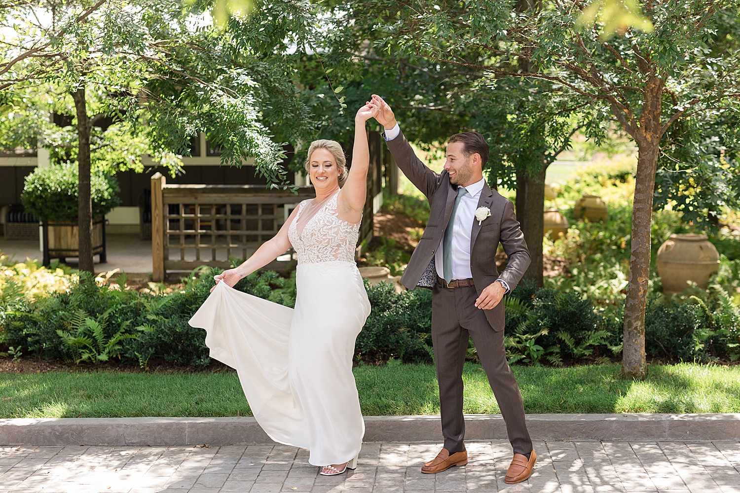 groom spins bride holding gown