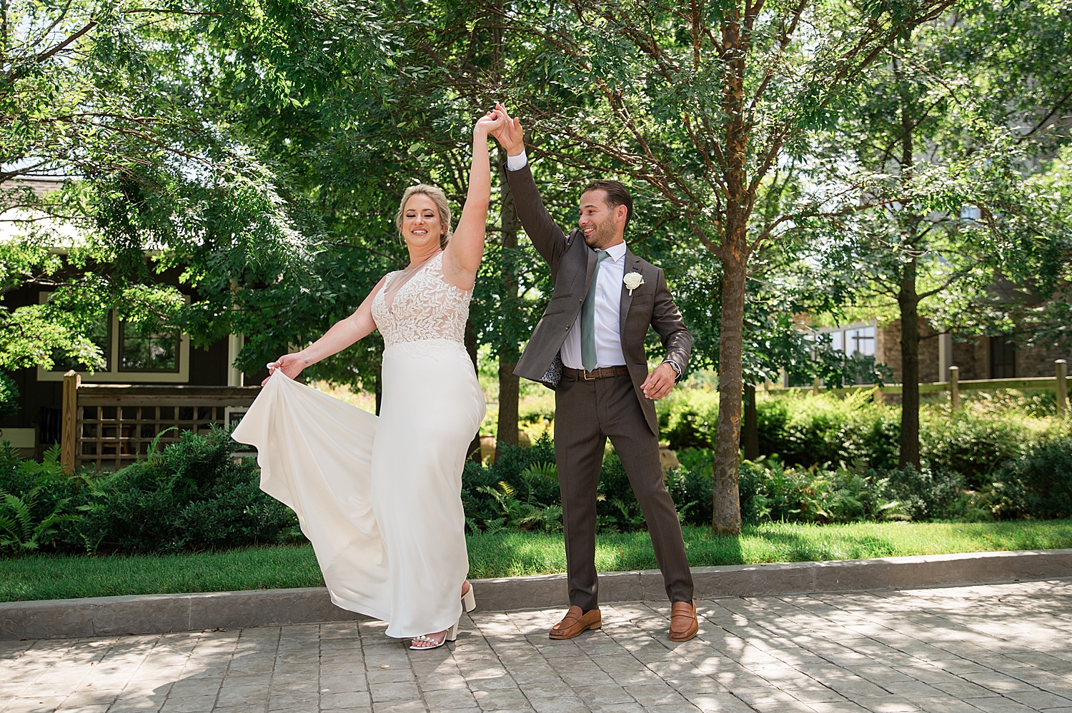 groom spins bride holding gown