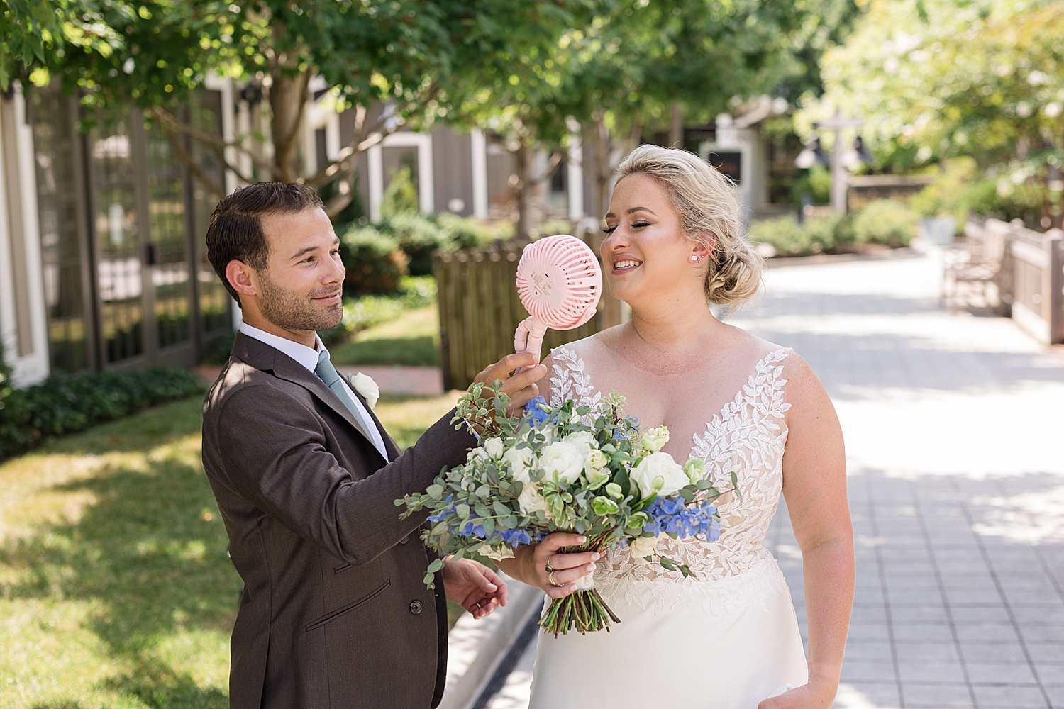 groom holding electric fan for bride outside