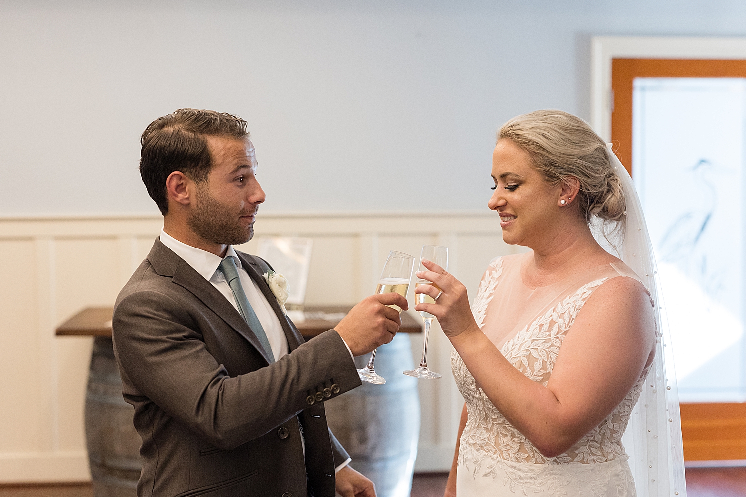 bride and groom clink glasses