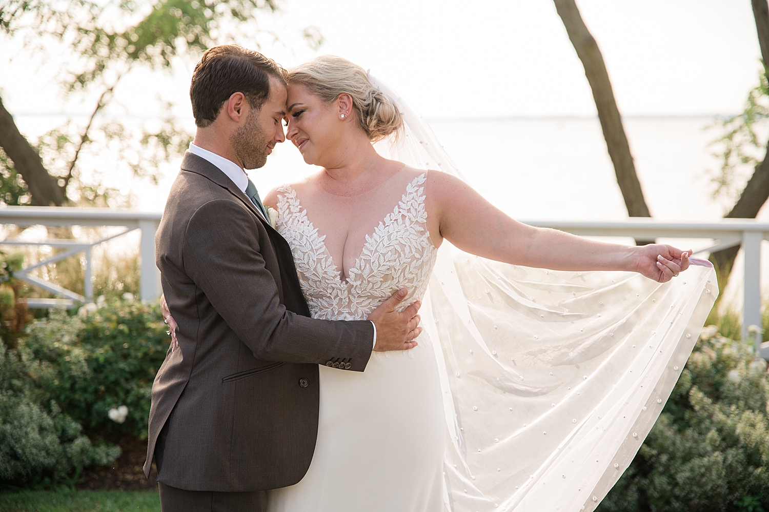 couple wedding portrait holding veil