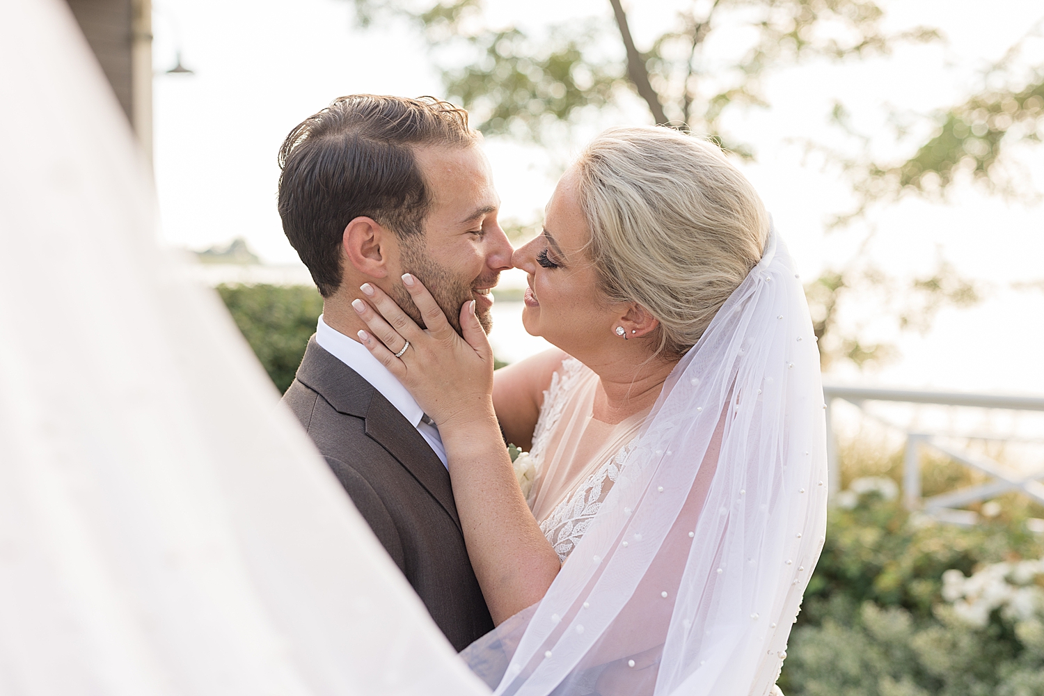 couple wedding portrait holding veil