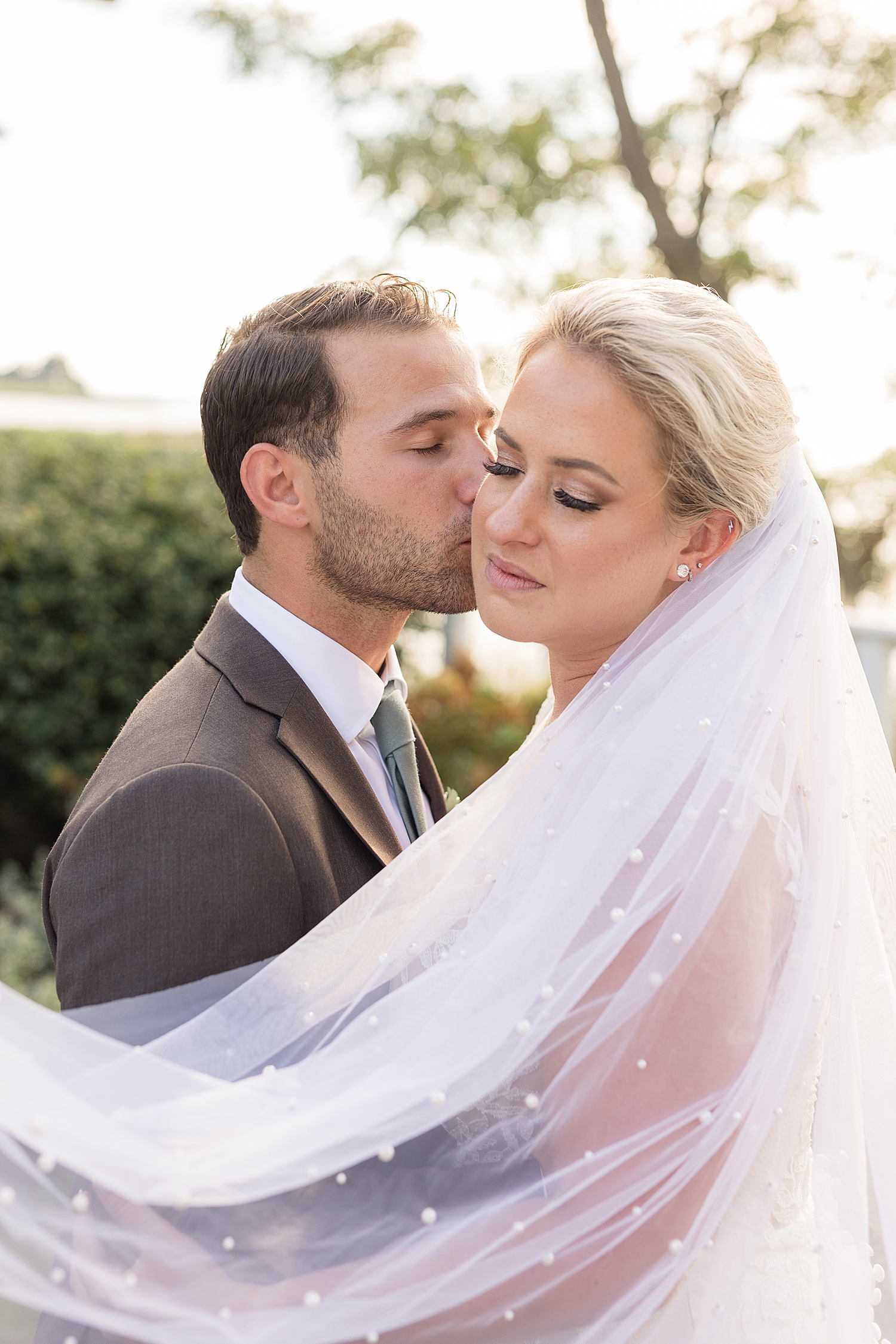 couple wedding portrait holding veil