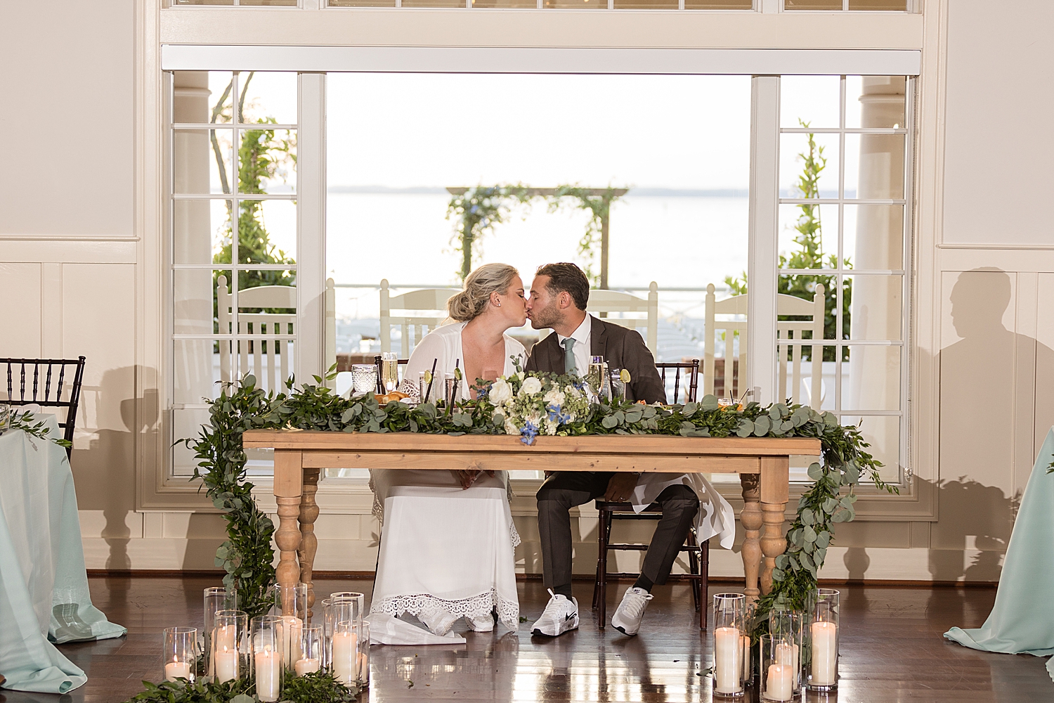 couple kissing at sweetheart table