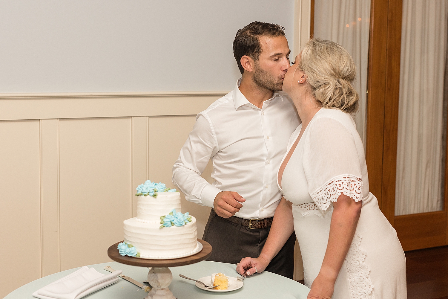 groom and bride cutting cake kiss