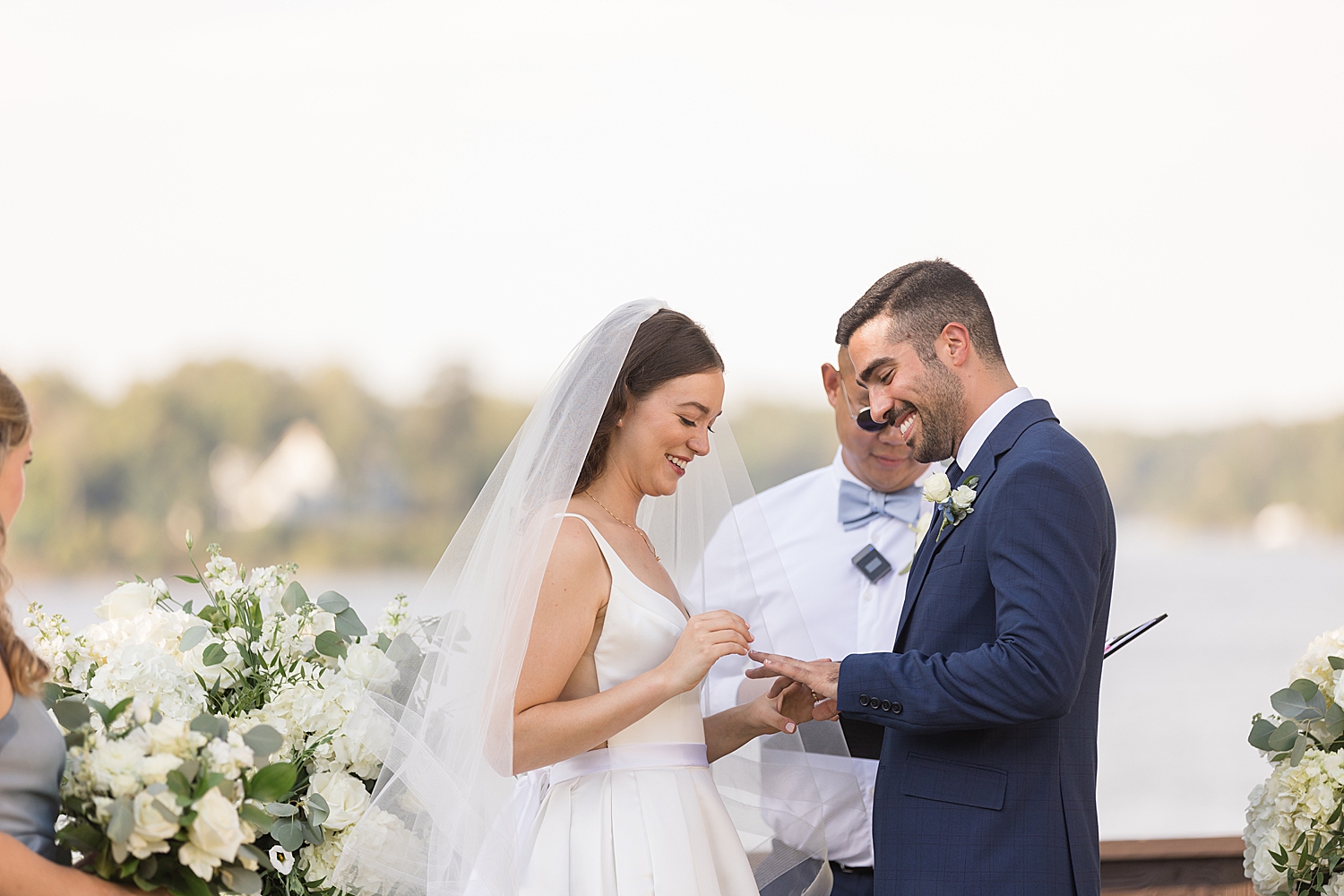 bride putting ring on groom's finger during ceremony