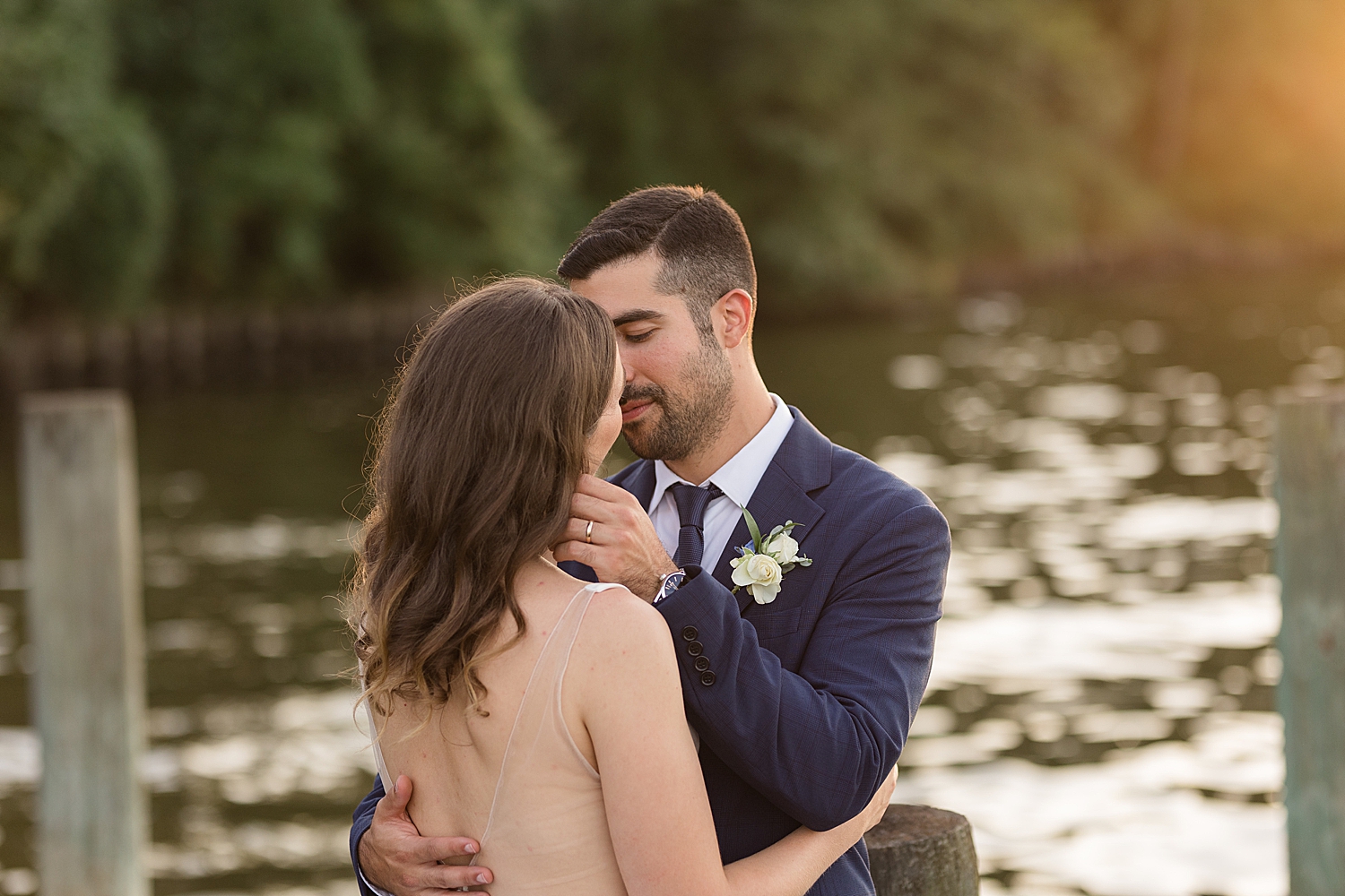 bride and groom on pier at sunset