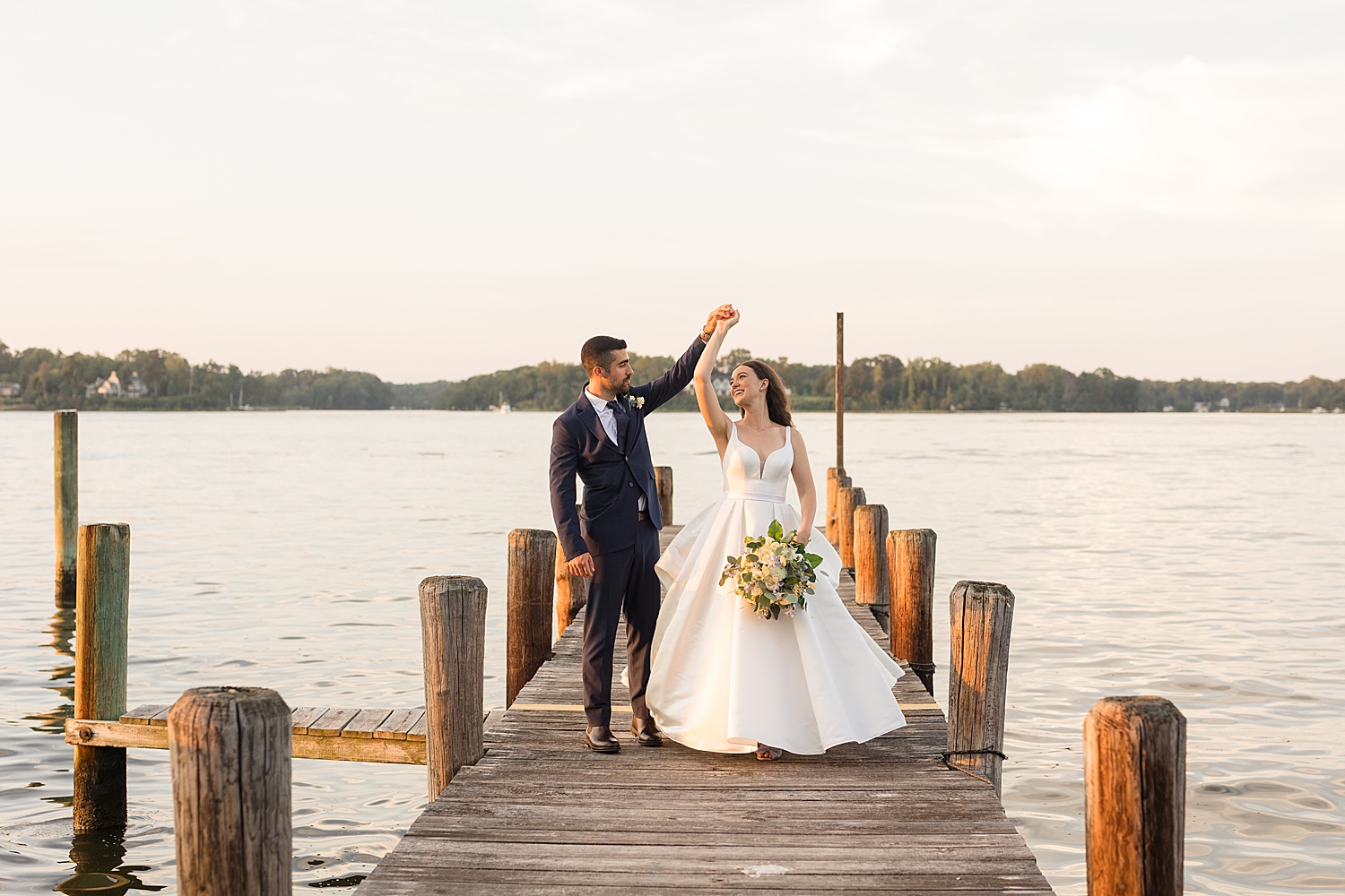 bride and groom on pier at sunset spin