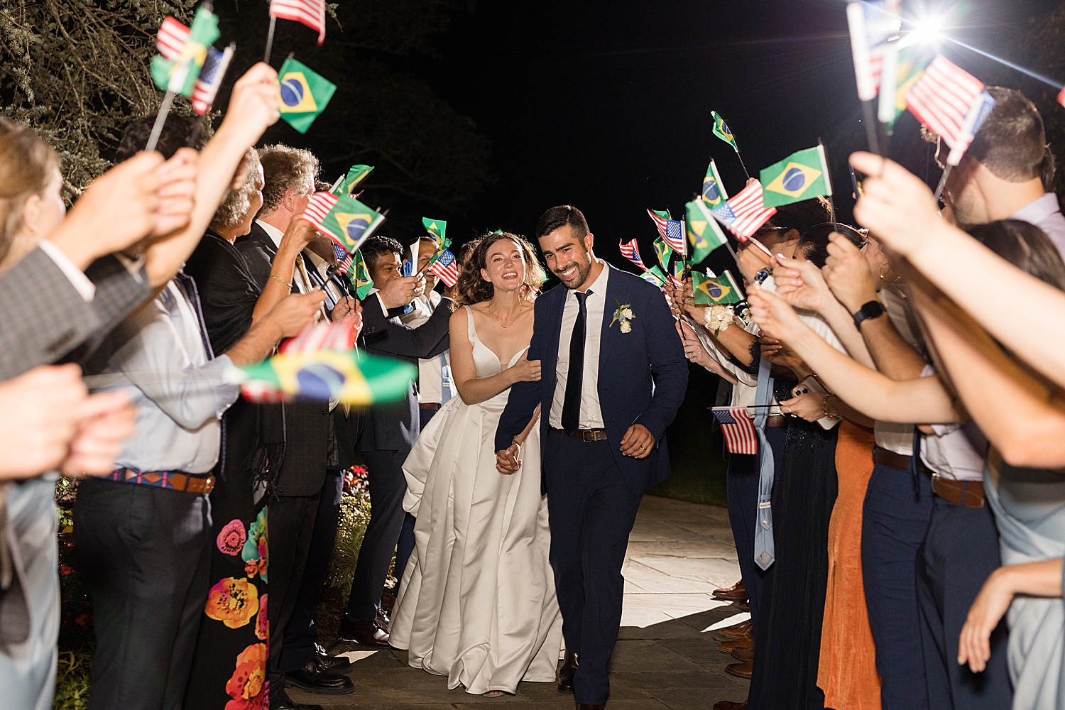 bride and groom exit with guests waving Brazilian flag