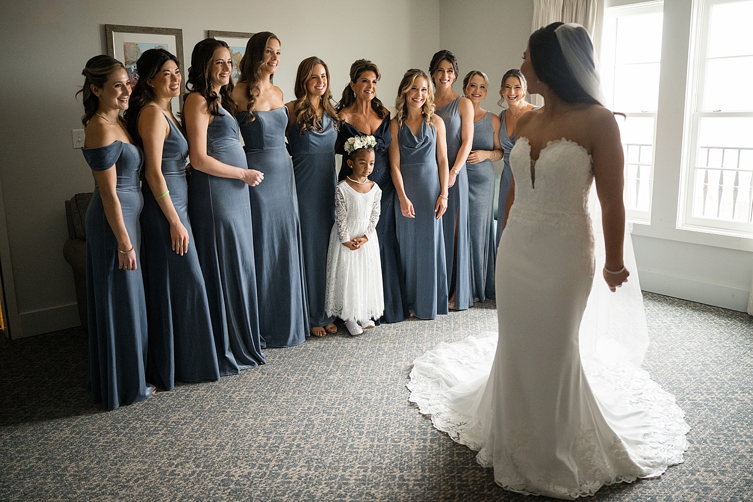 bride showing off dress to bridesmaids