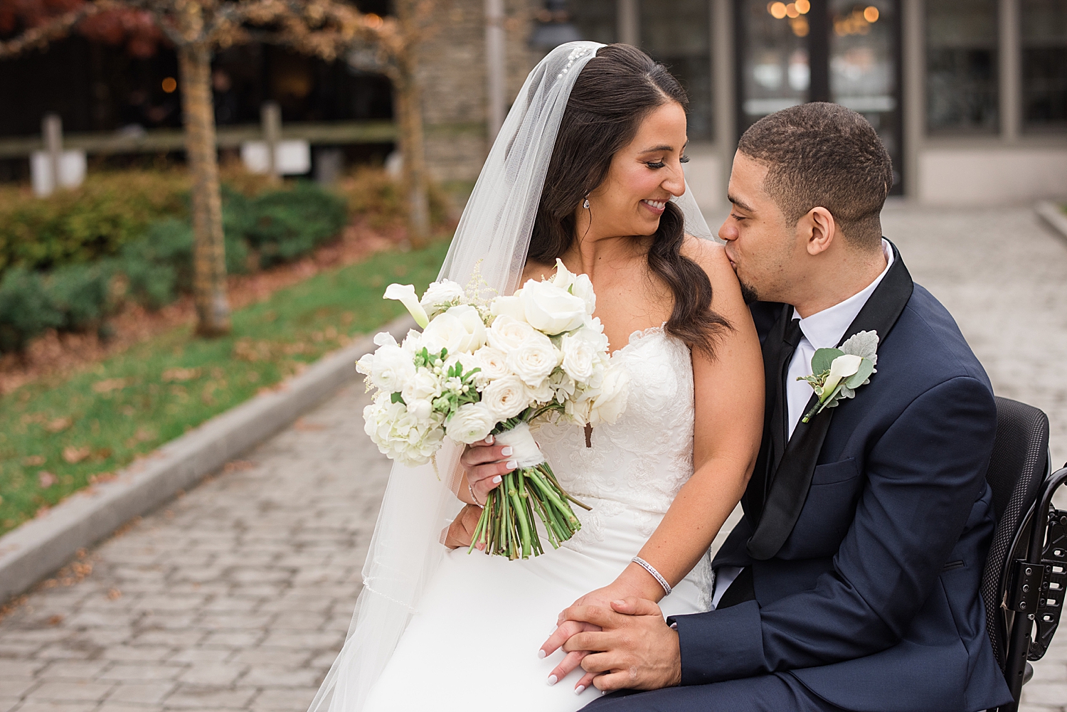 bride and groom portrait wheelchair kiss shoulder