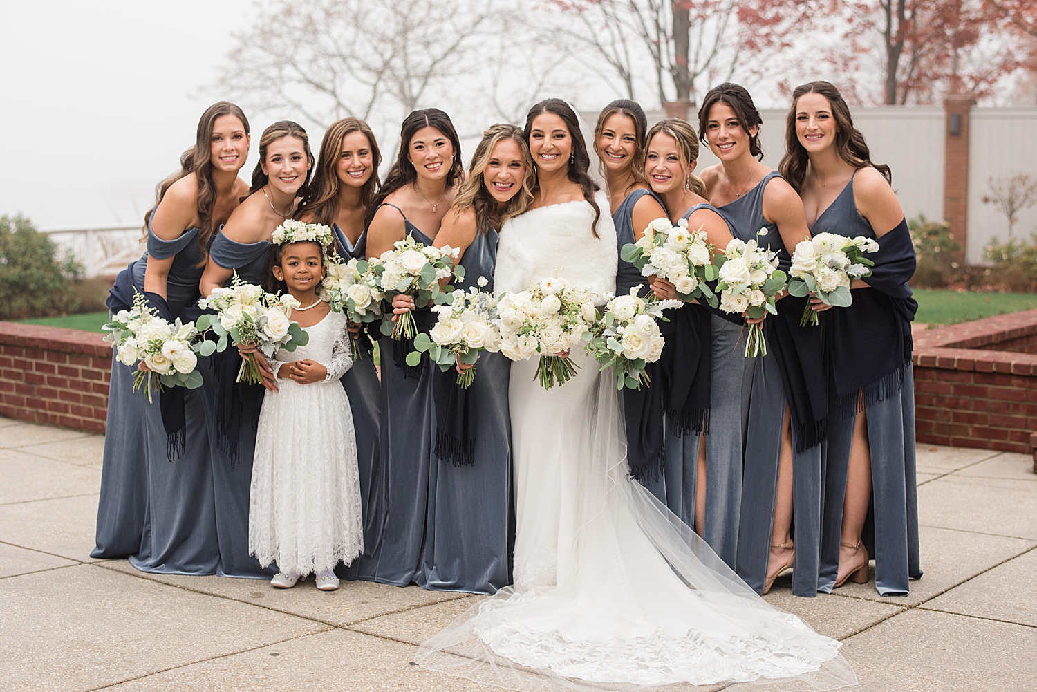 bride and bridesmaids hugging winter wedding