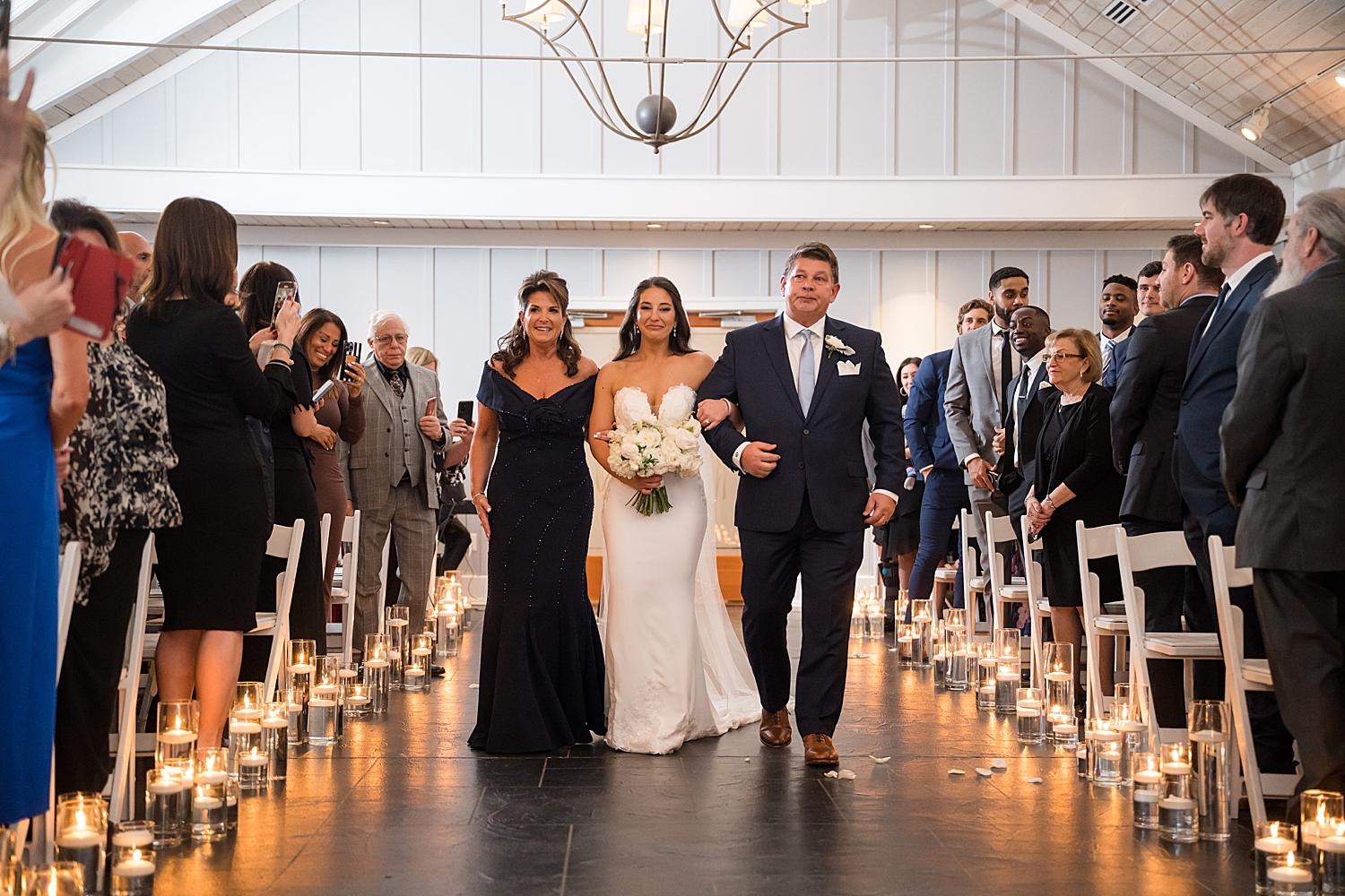 bride walking down the aisle with her parents