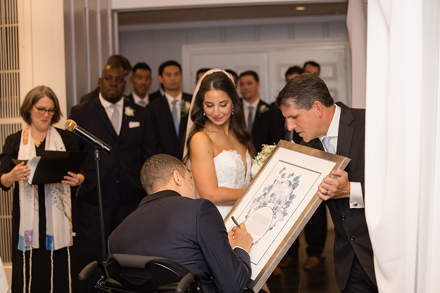 bride and groom sign ketubah