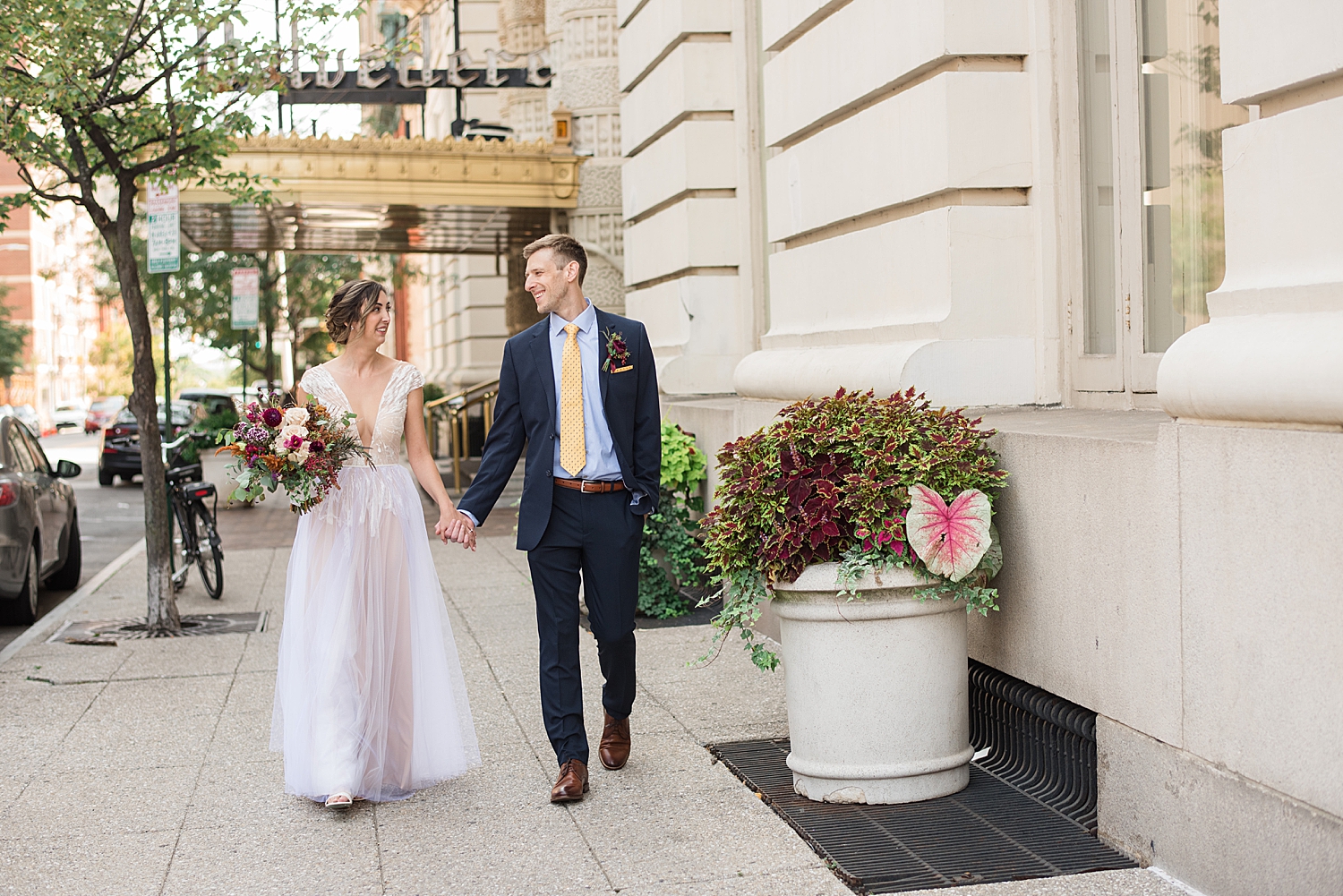 bride and groom walk in front of belvedere hotel