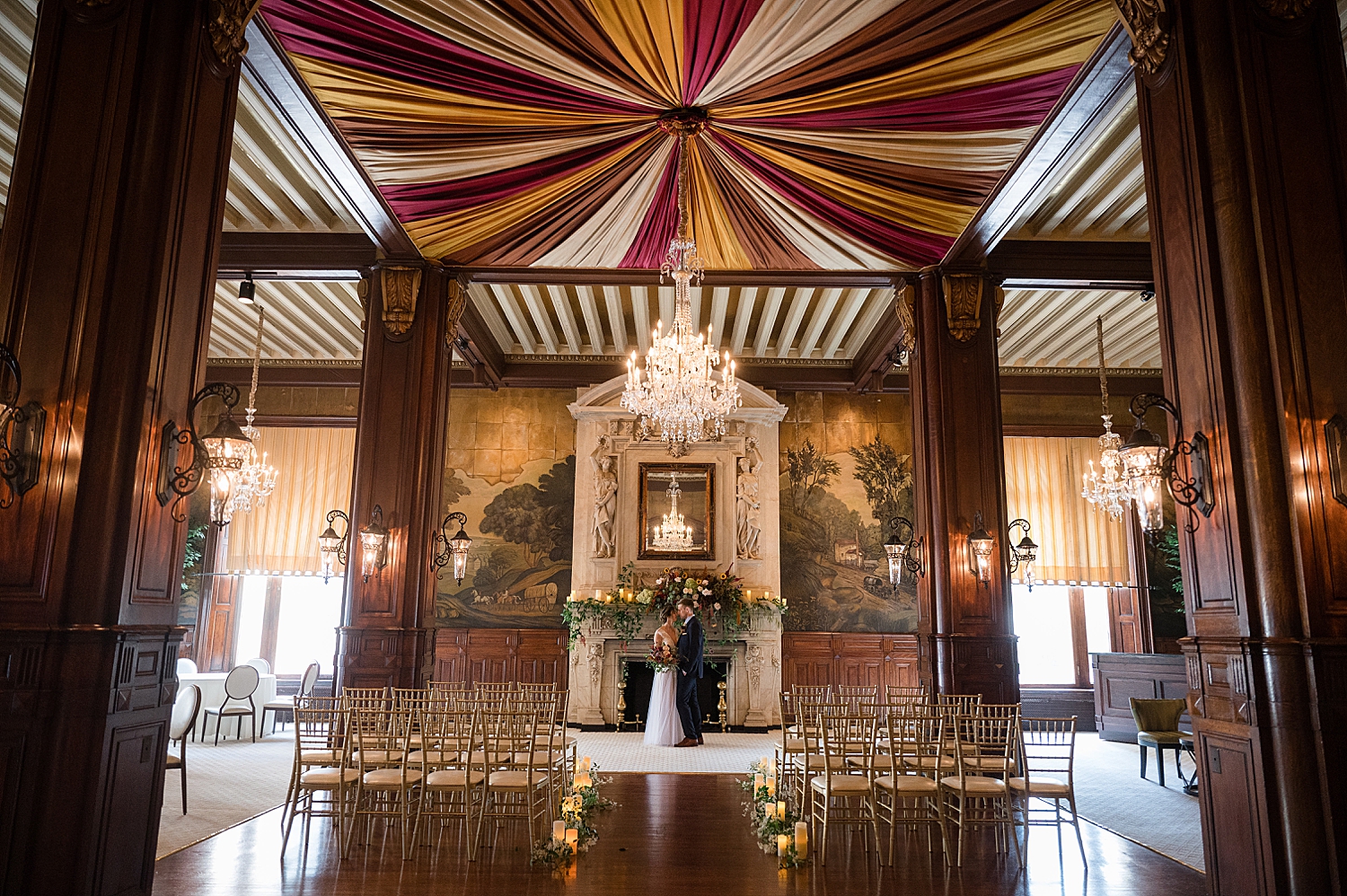 bride and groom kiss in front of belvedere event fireplace