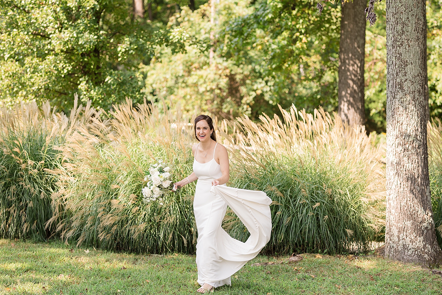 bride laughing and holding train of gown