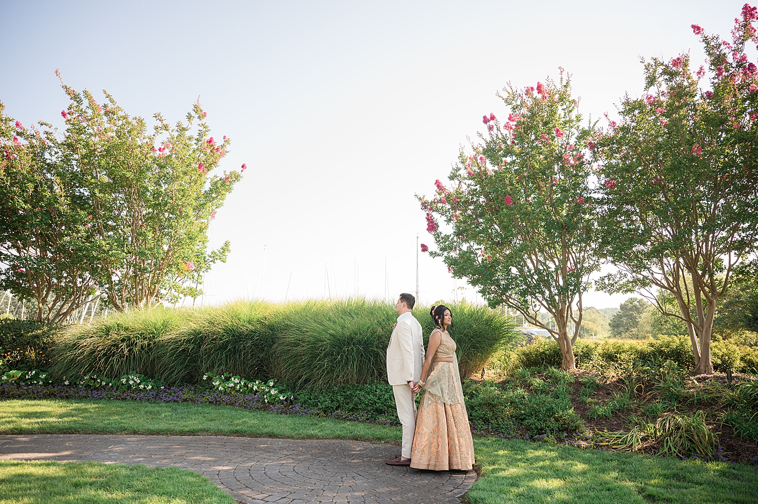 bride and groom back to back wide portrait