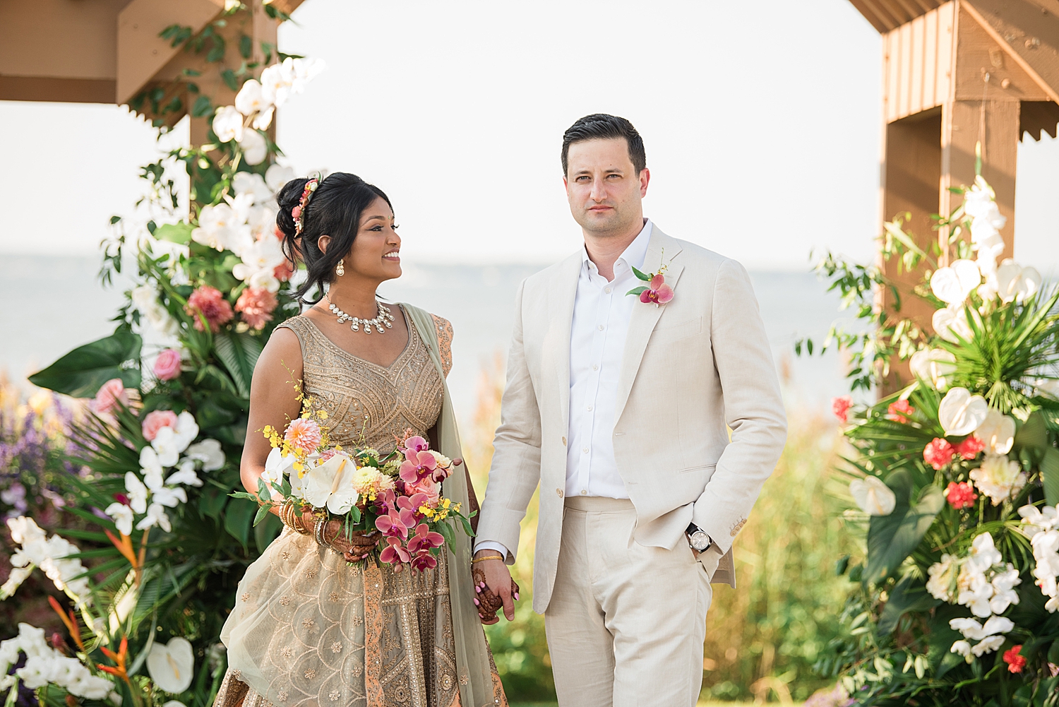 bride admires groom while groom smiles at camera