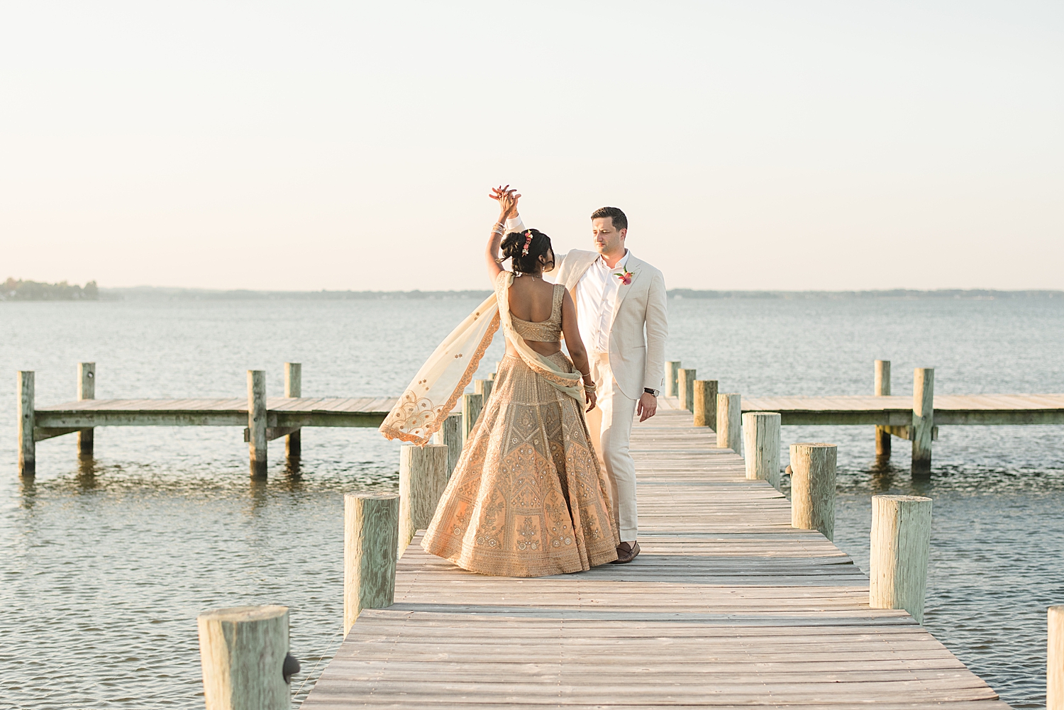 bride and groom dancing on pier