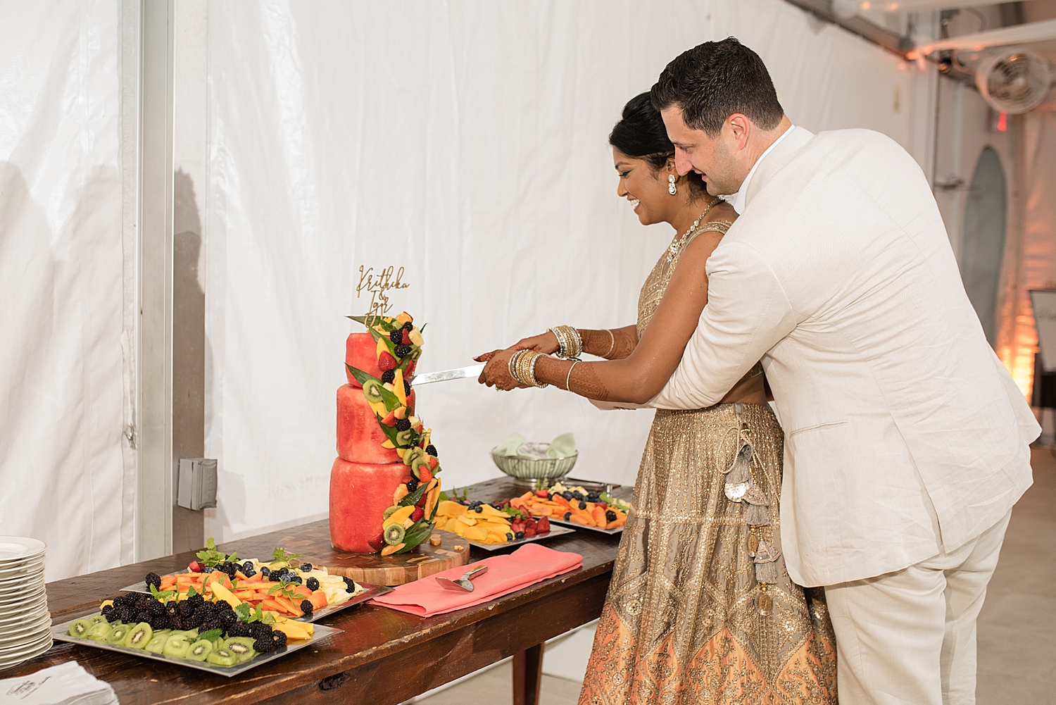 bride and groom cut cake made from melon