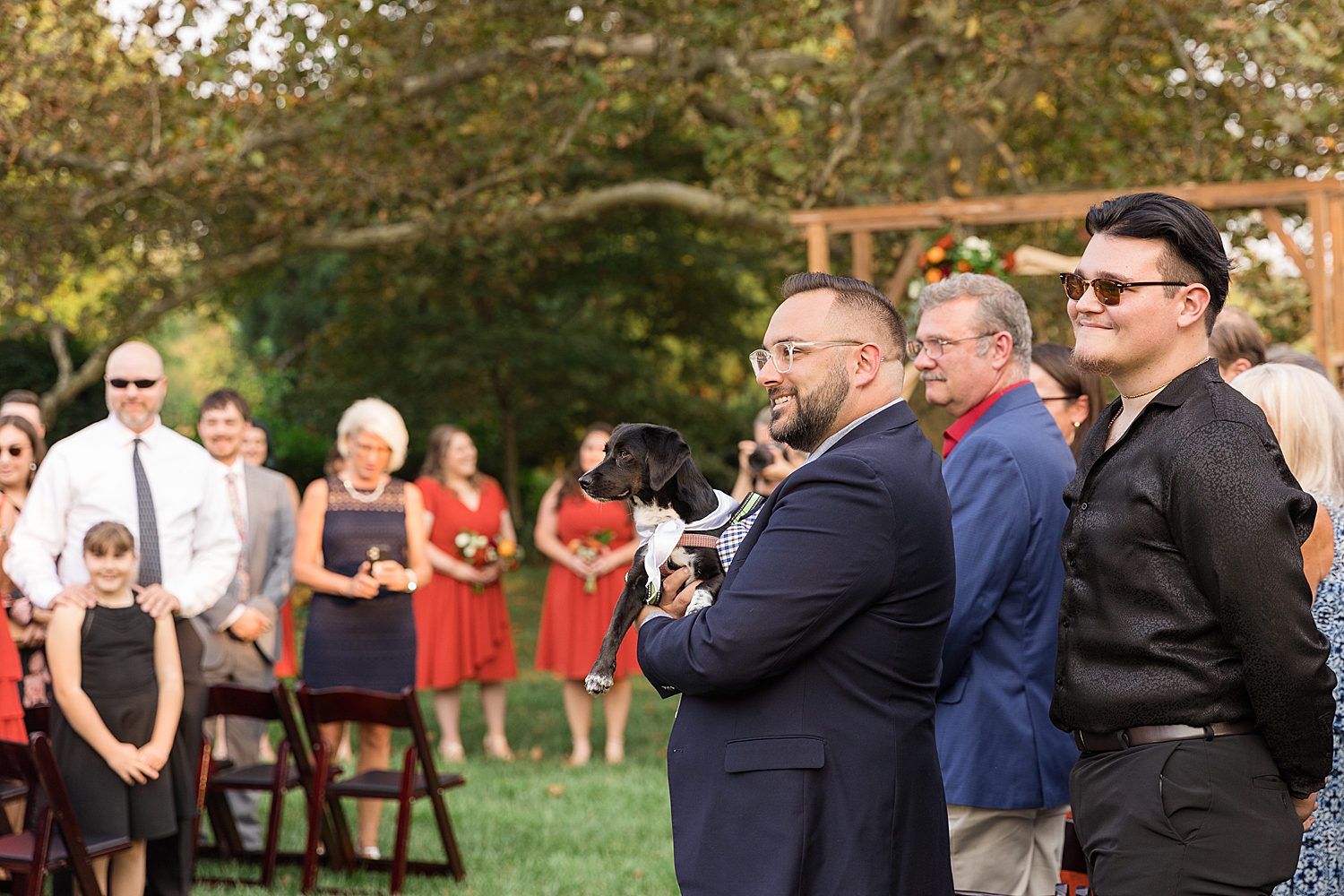 guests and dog watching bride process down aisle