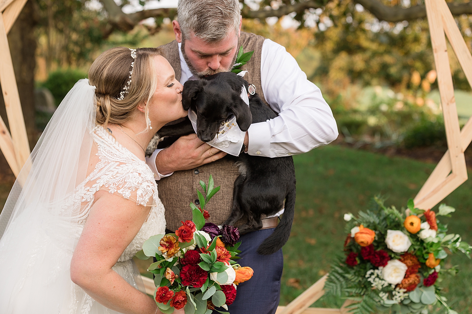 bride and groom kissing their dog