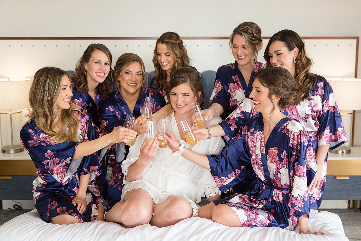 bride and bridesmaids getting ready cheering champagne