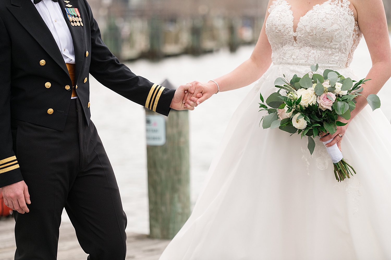 groom and bride holding hands on annapolis dock