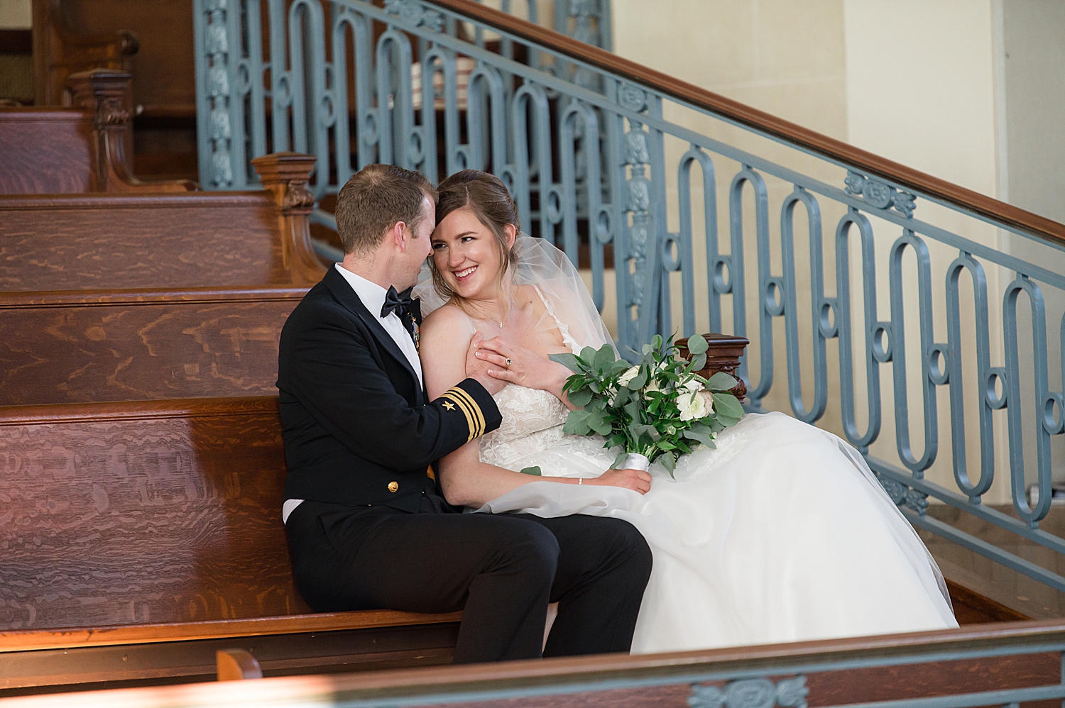 bride and groom cuddle in usna chapel loft