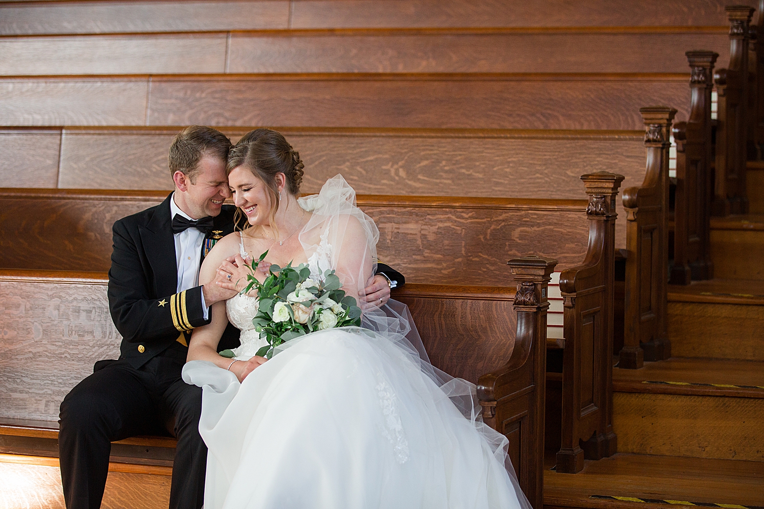 bride and groom cuddle in usna chapel loft