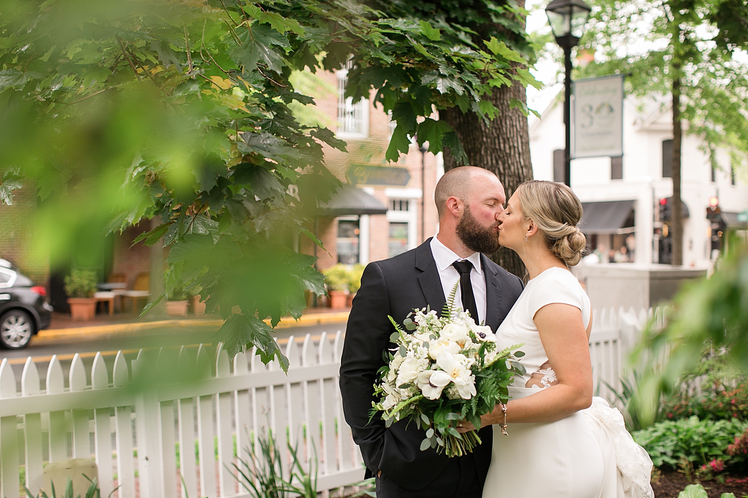 bride and groom kiss under trees