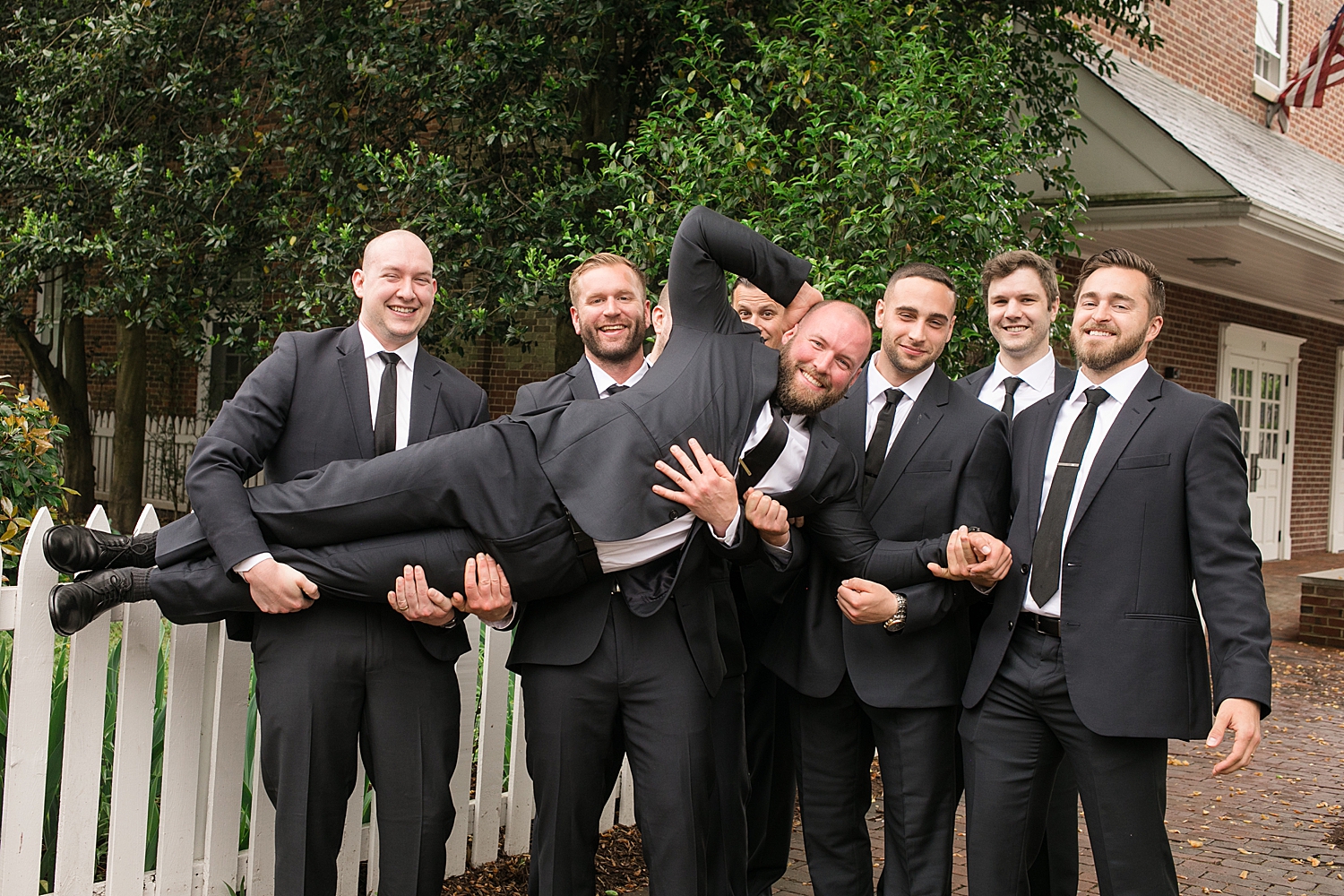 groomsmen hold groom