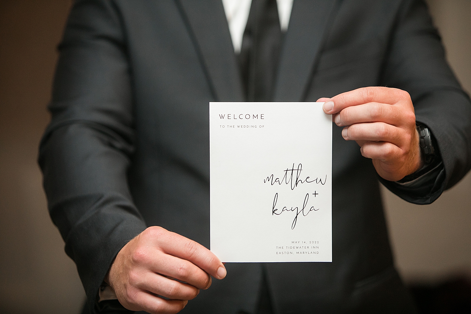 groom holds wedding invitation