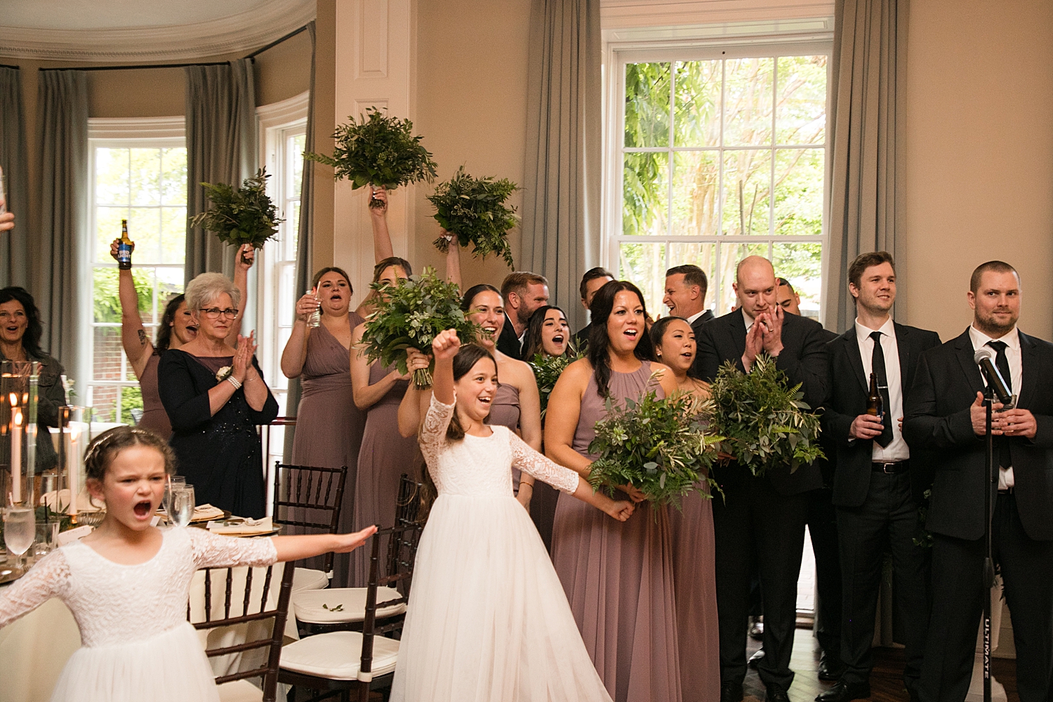 wedding party cheering as bride and groom enter reception