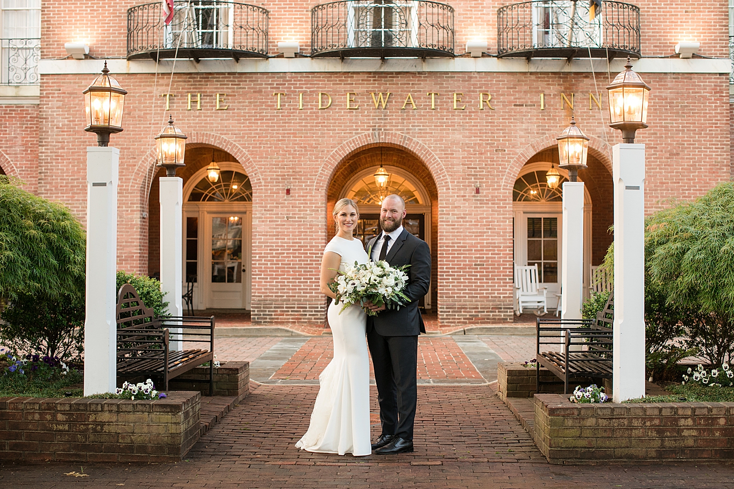 bride and groom in front of tidewater inn brick arches