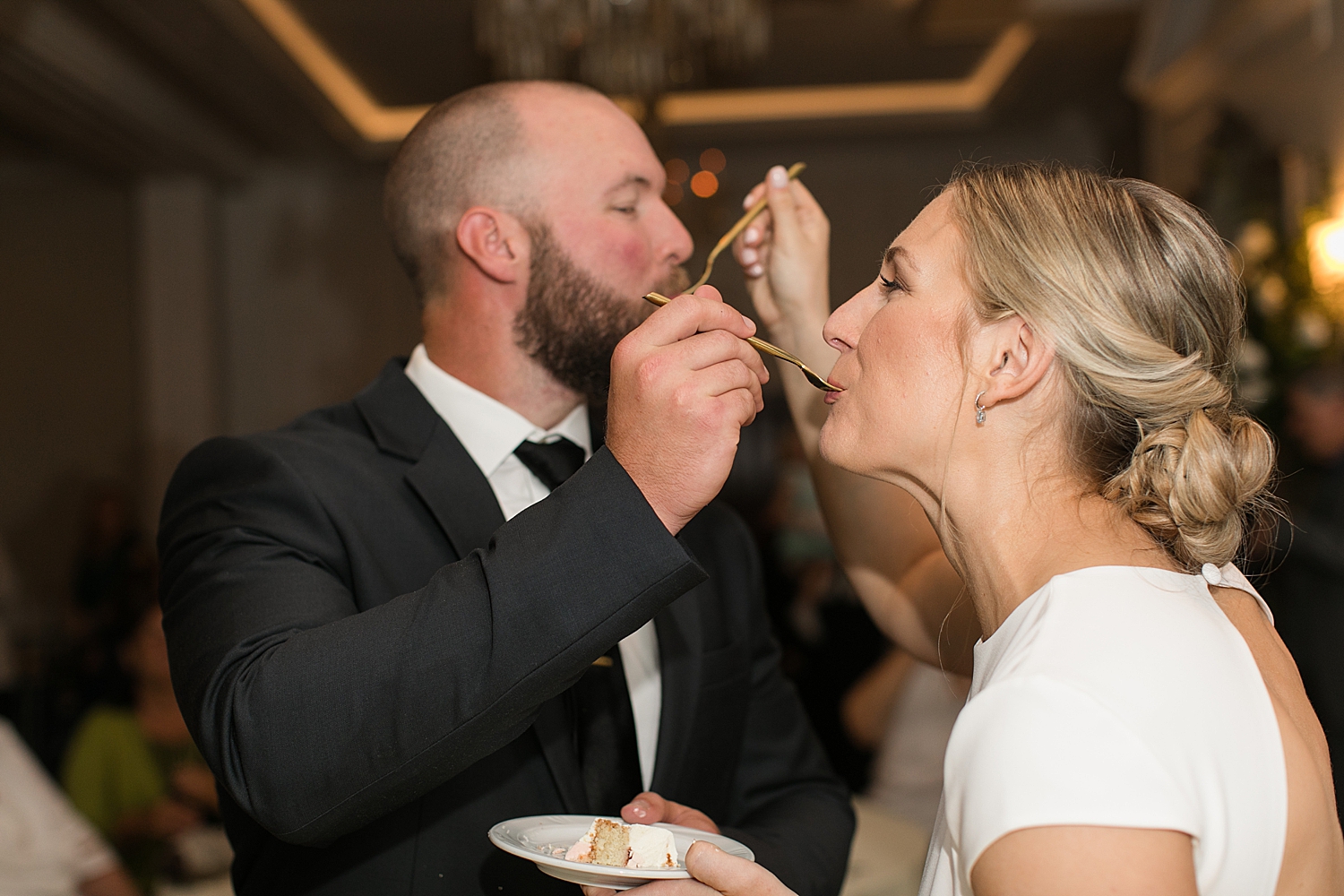 bride and groom feed each other cake