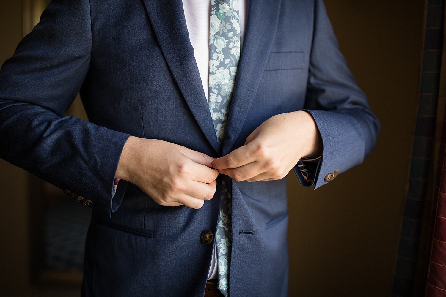 groom buttoning jacket