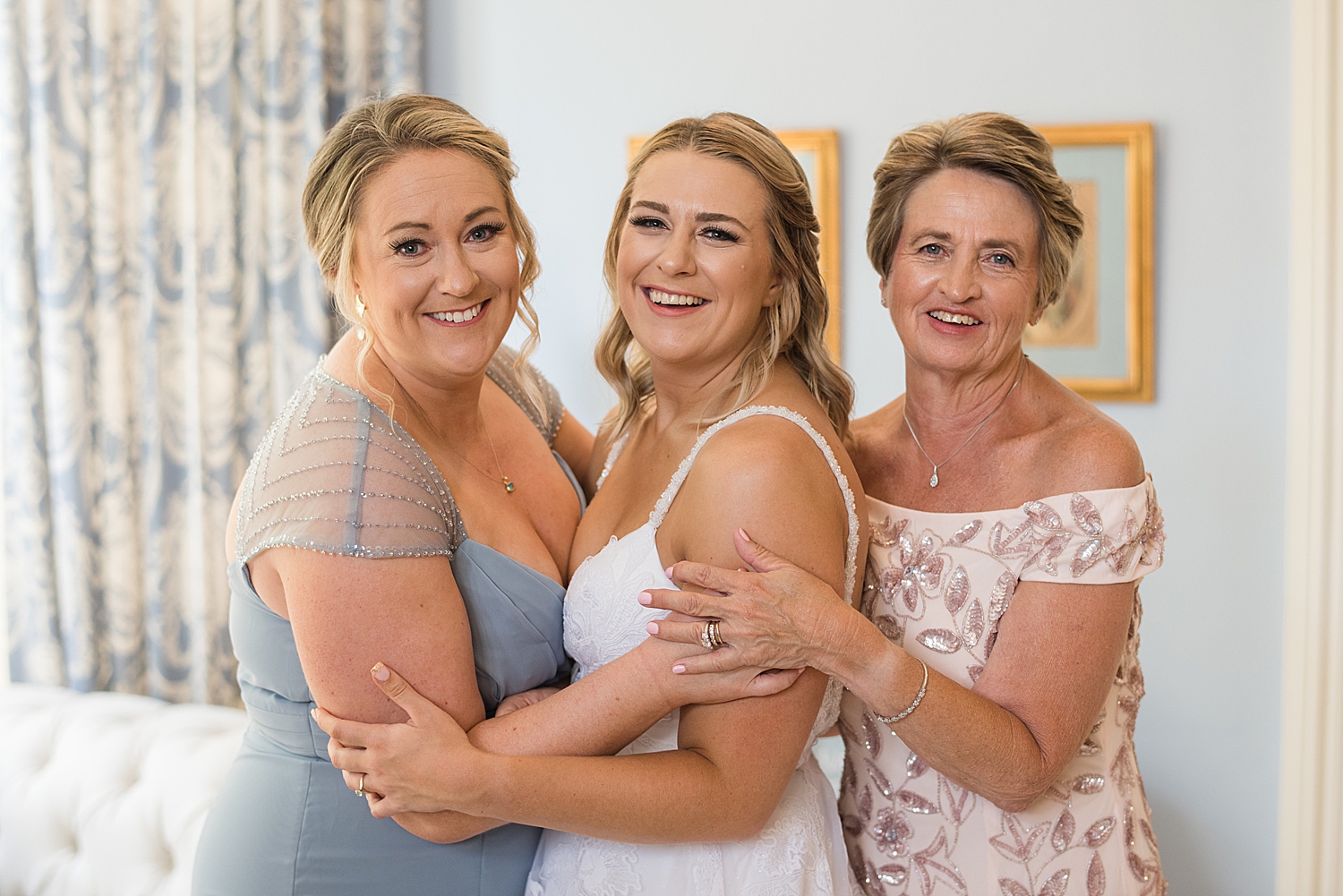 bride smiles with mom and sister