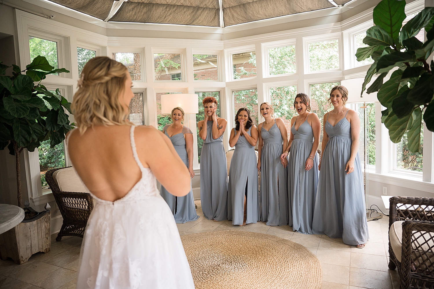 bride revealing gown to bridesmaids