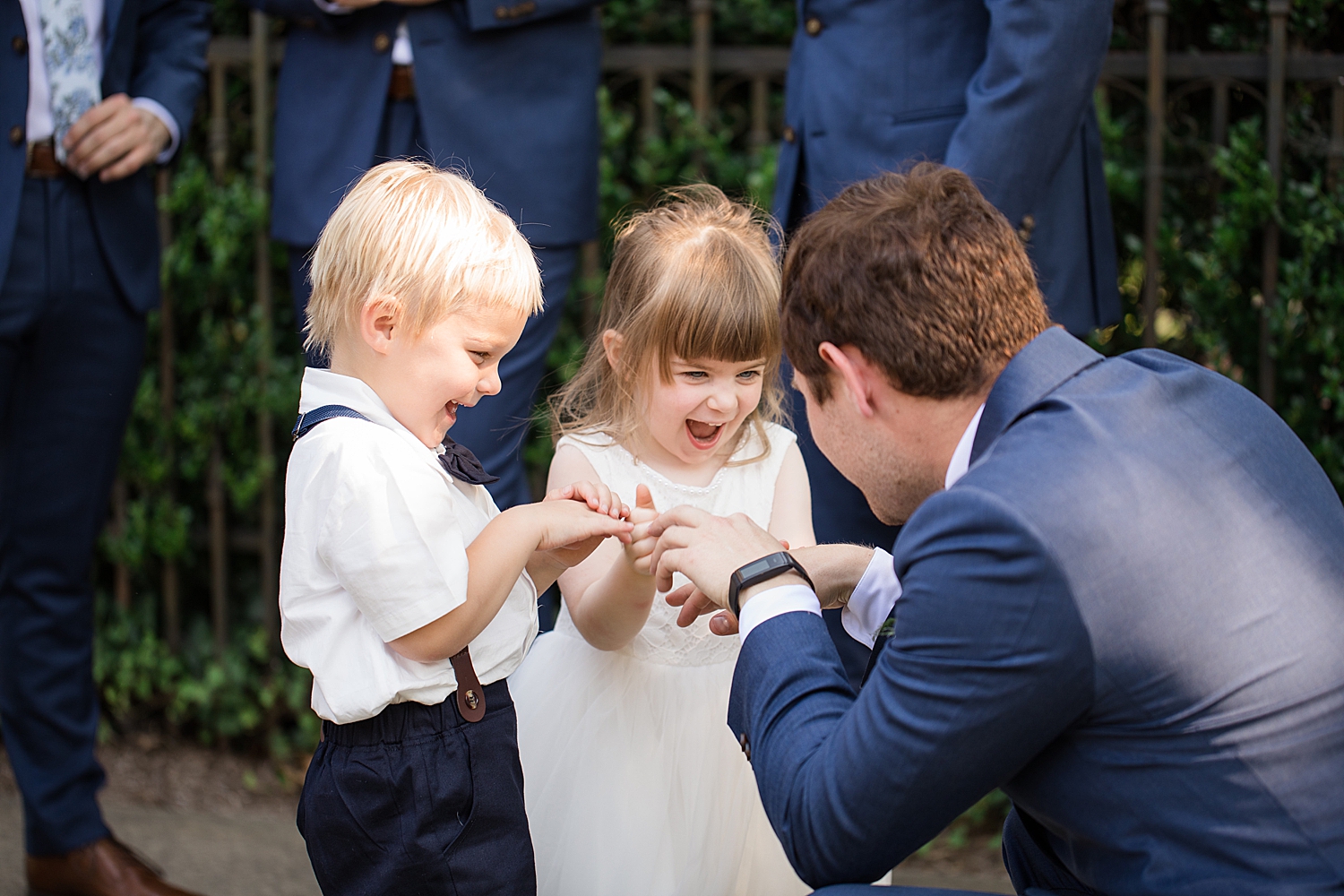 groom shows flower girl and ring bearer his ring