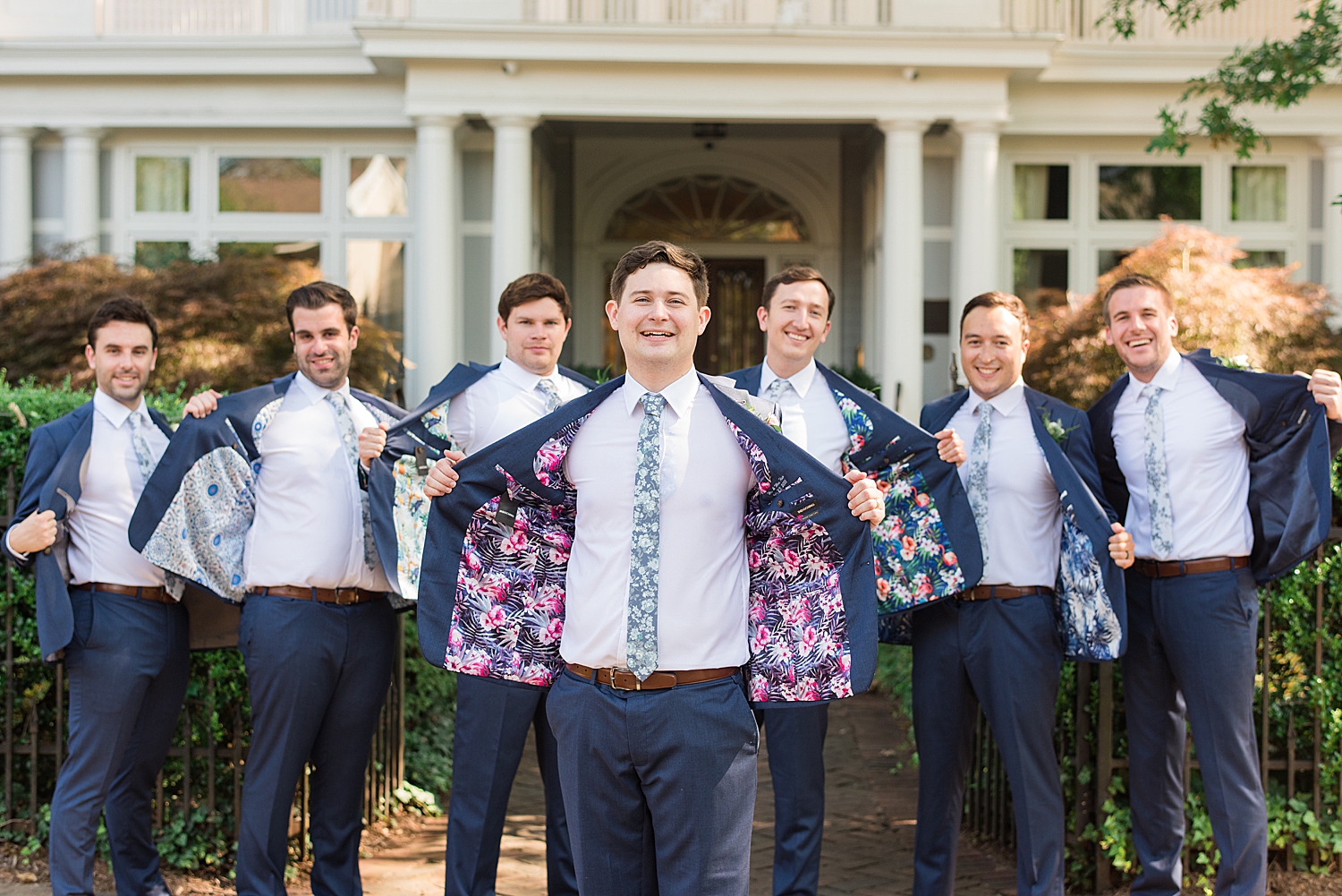 groom and groomsmen show off custom inner suit lining