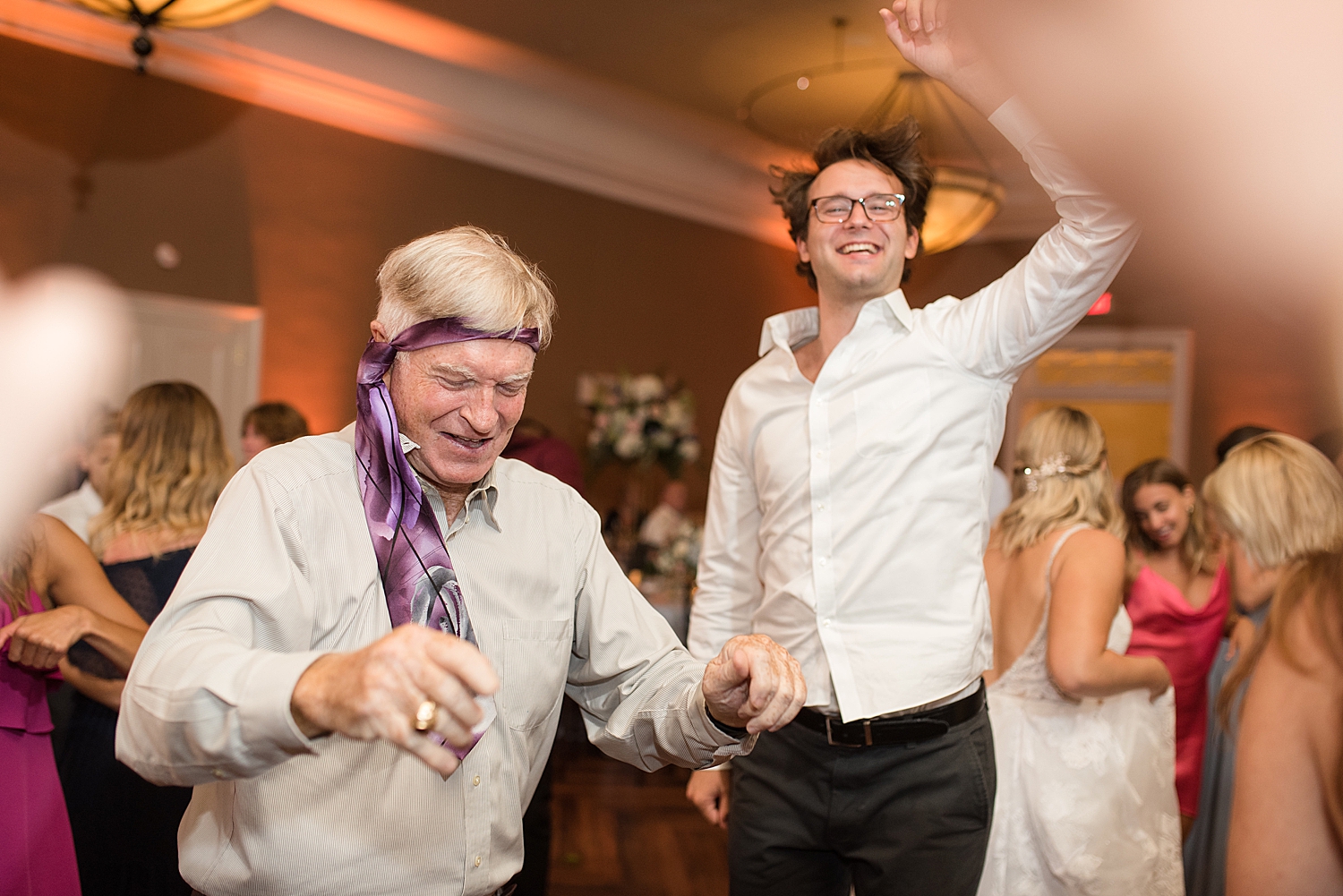 candid wedding dancing, guest with tie on head