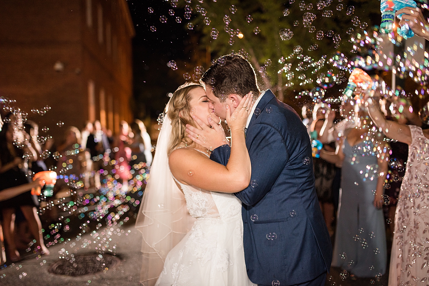 bride and groom celebratory bubble exit kiss