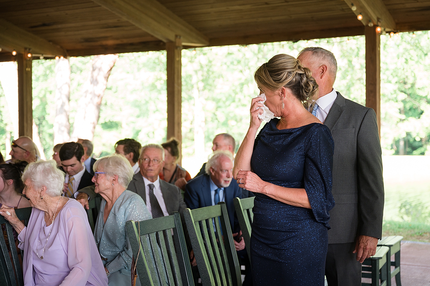 groom's parents dabbing tears before ceremony