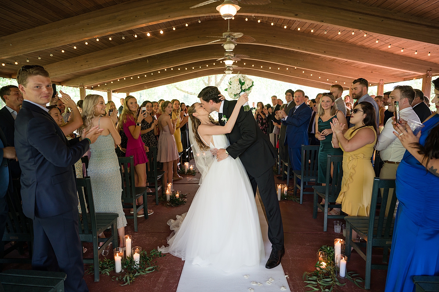 bride and groom kiss in the aisle as they recess