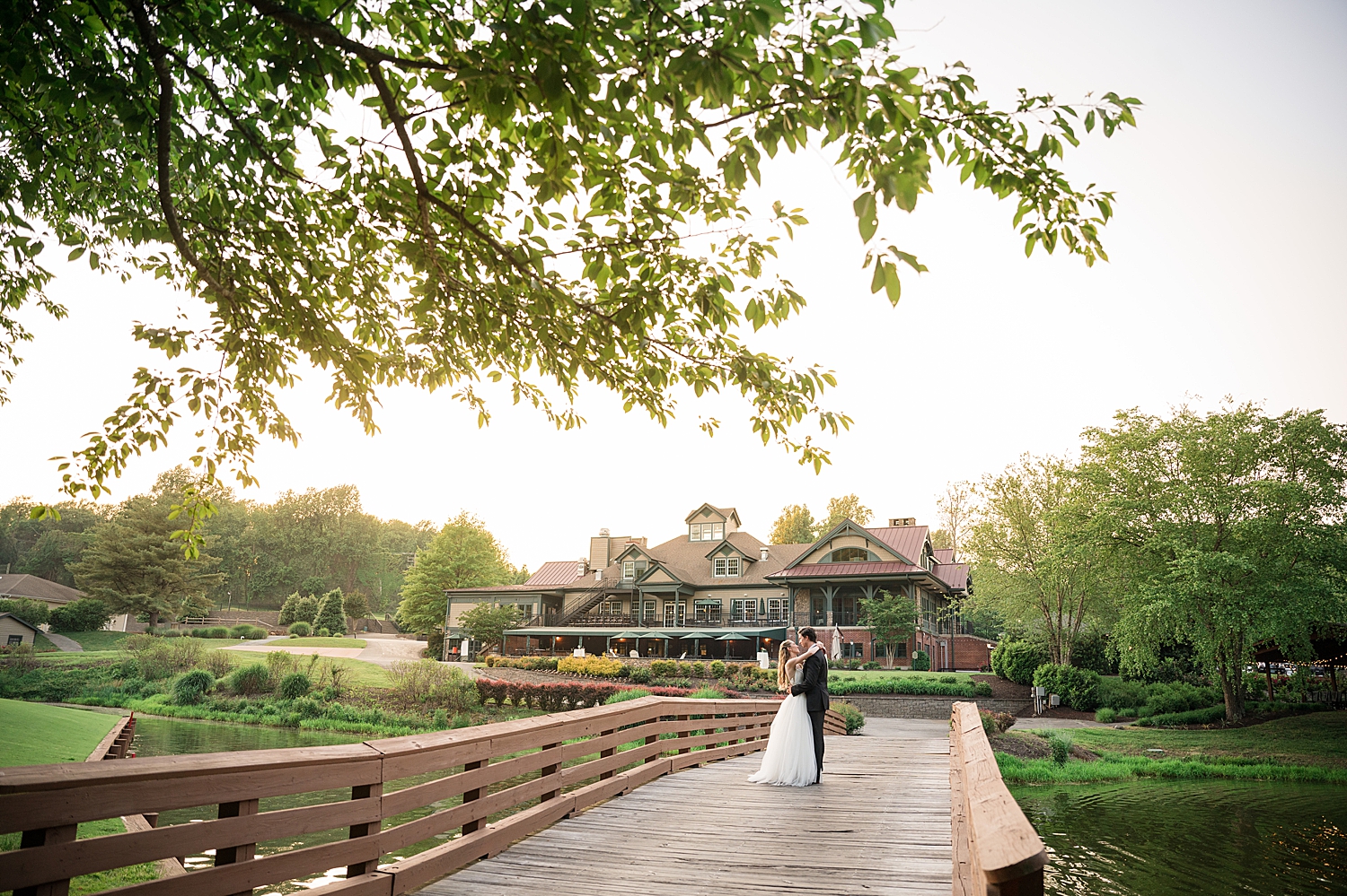 couple portrait on bridge with golf club in the background