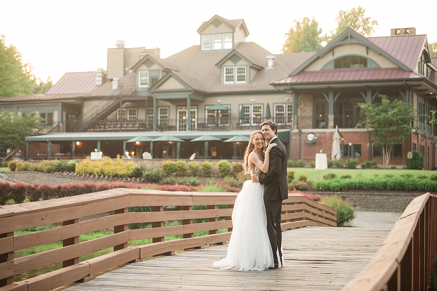 couple portrait on bridge with golf club in the background