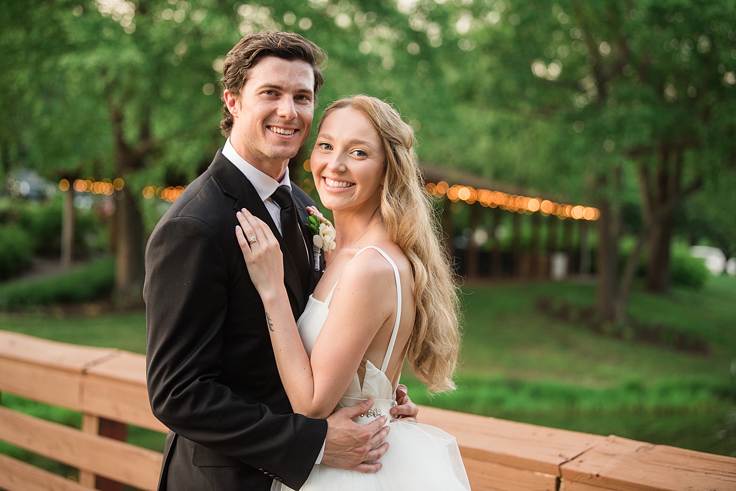 couple portrait on bridge with golf club in the background